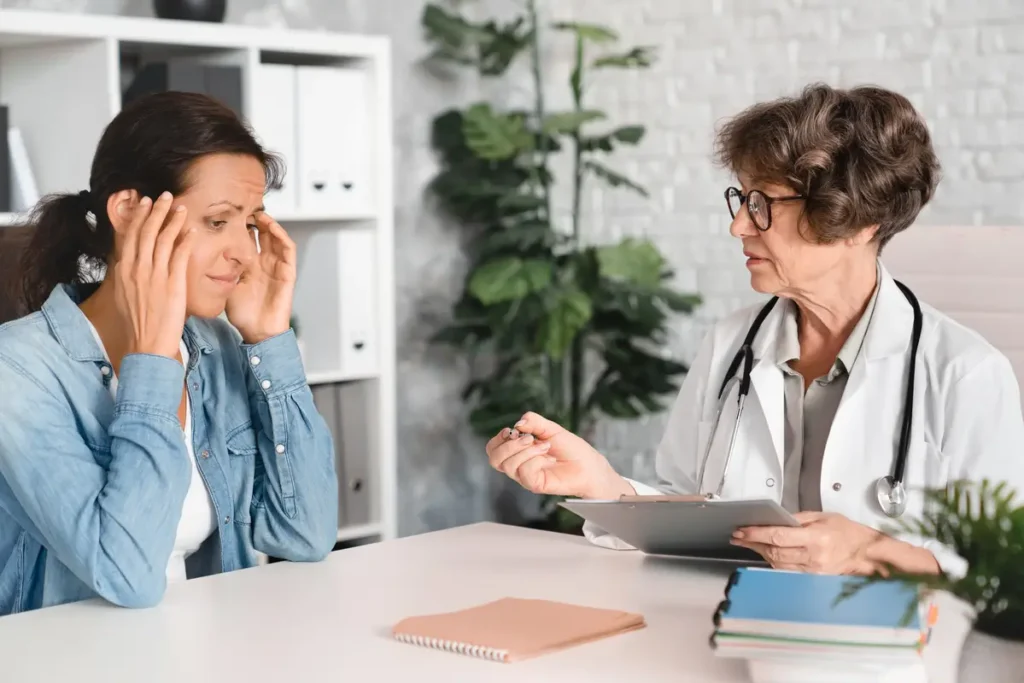 Síntomas y tratamiento de la menopausia 3 síntomas de la menopausia Médico hablando con paciente – consulta menopausia tratamiento