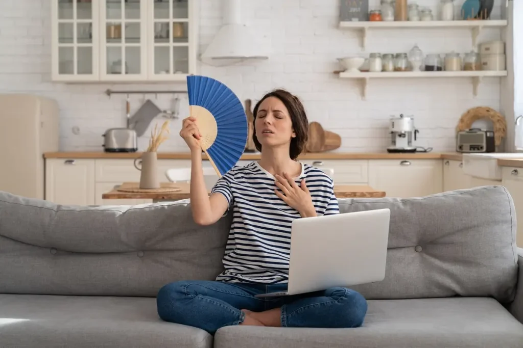 Mujer usando abanico – sofocones durante la menopausia